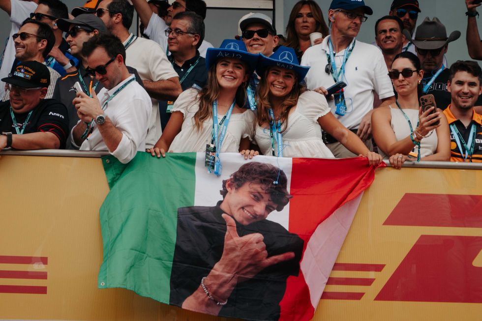 Two young girls hold a flag with Kimi Antonelli's face on it at the 2026 U.S. Grand Prix