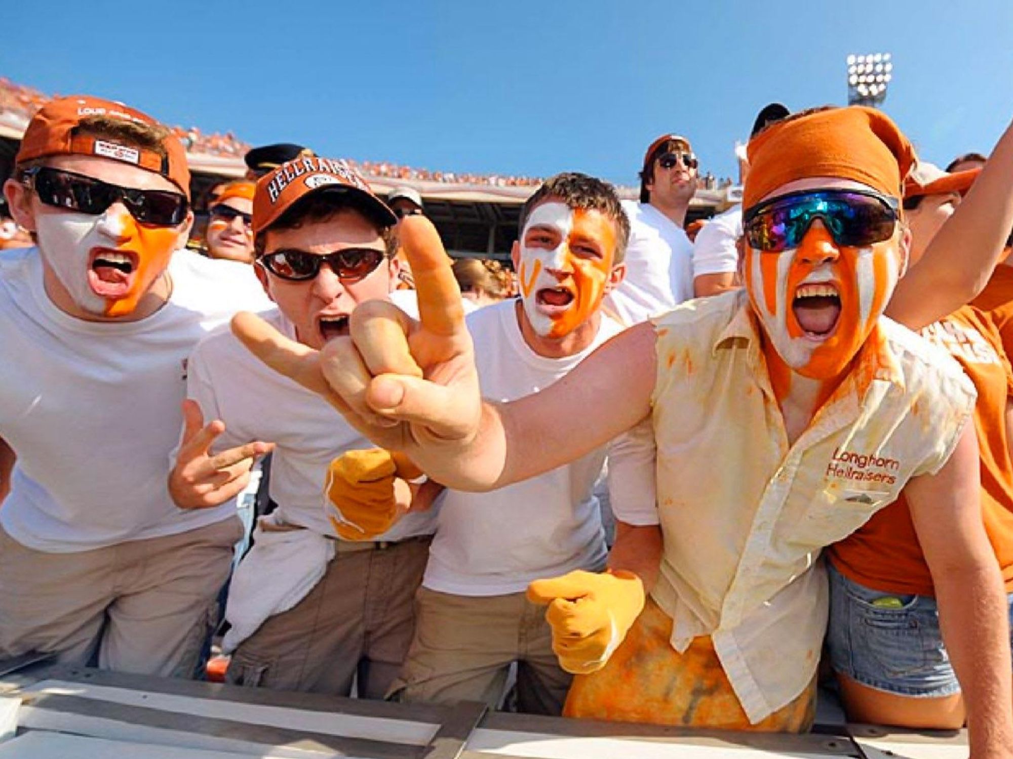 University of Texas at Austin hellraisers guys with painted faces at football game partying