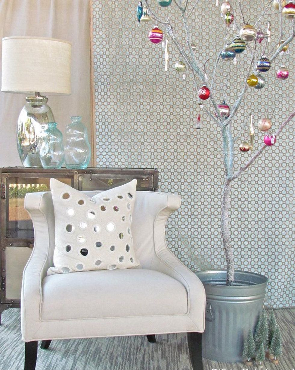 Vintage ornaments on a tree stump in a feed-store bucket