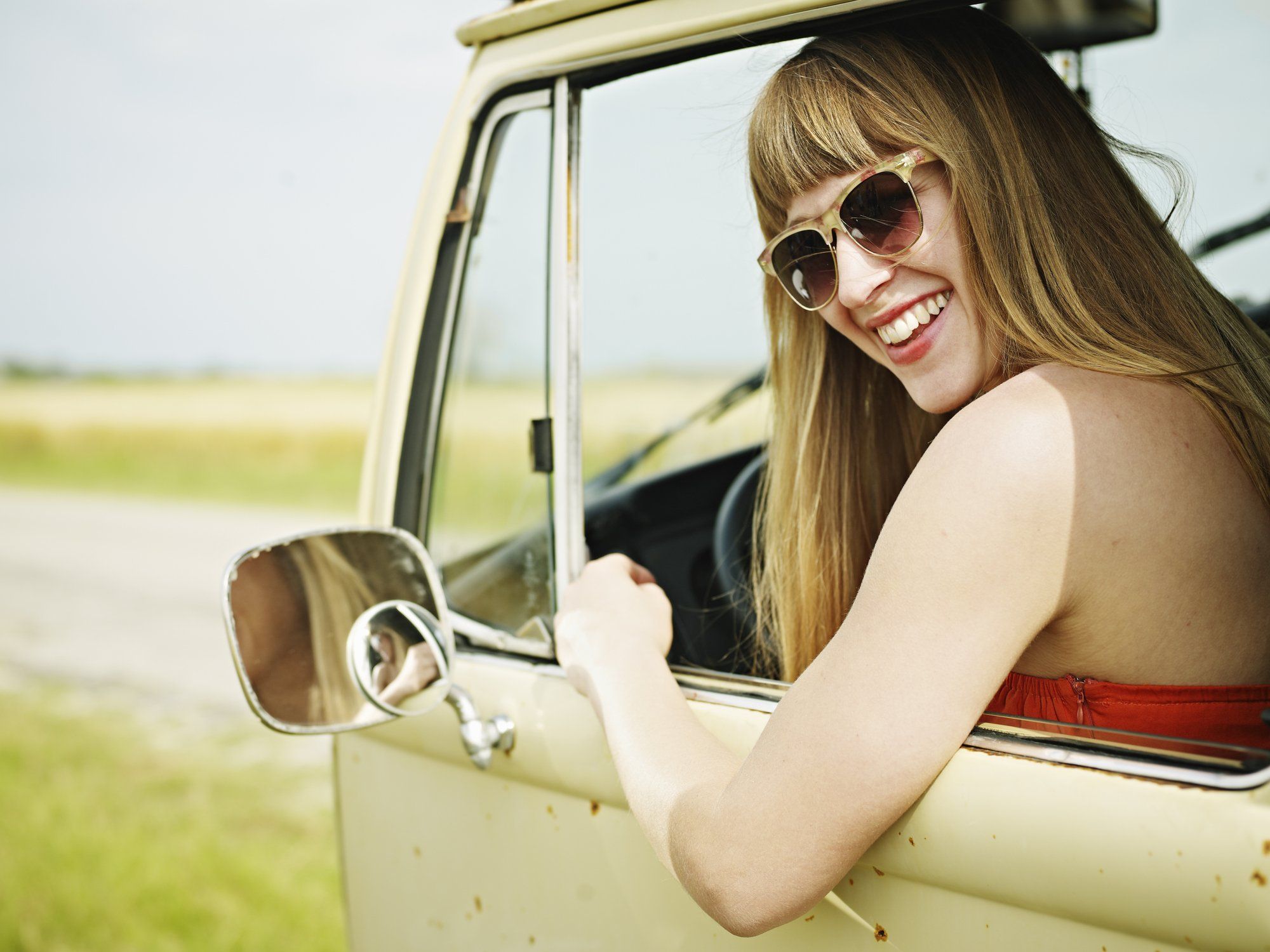 Woman driving vintage van on road trip