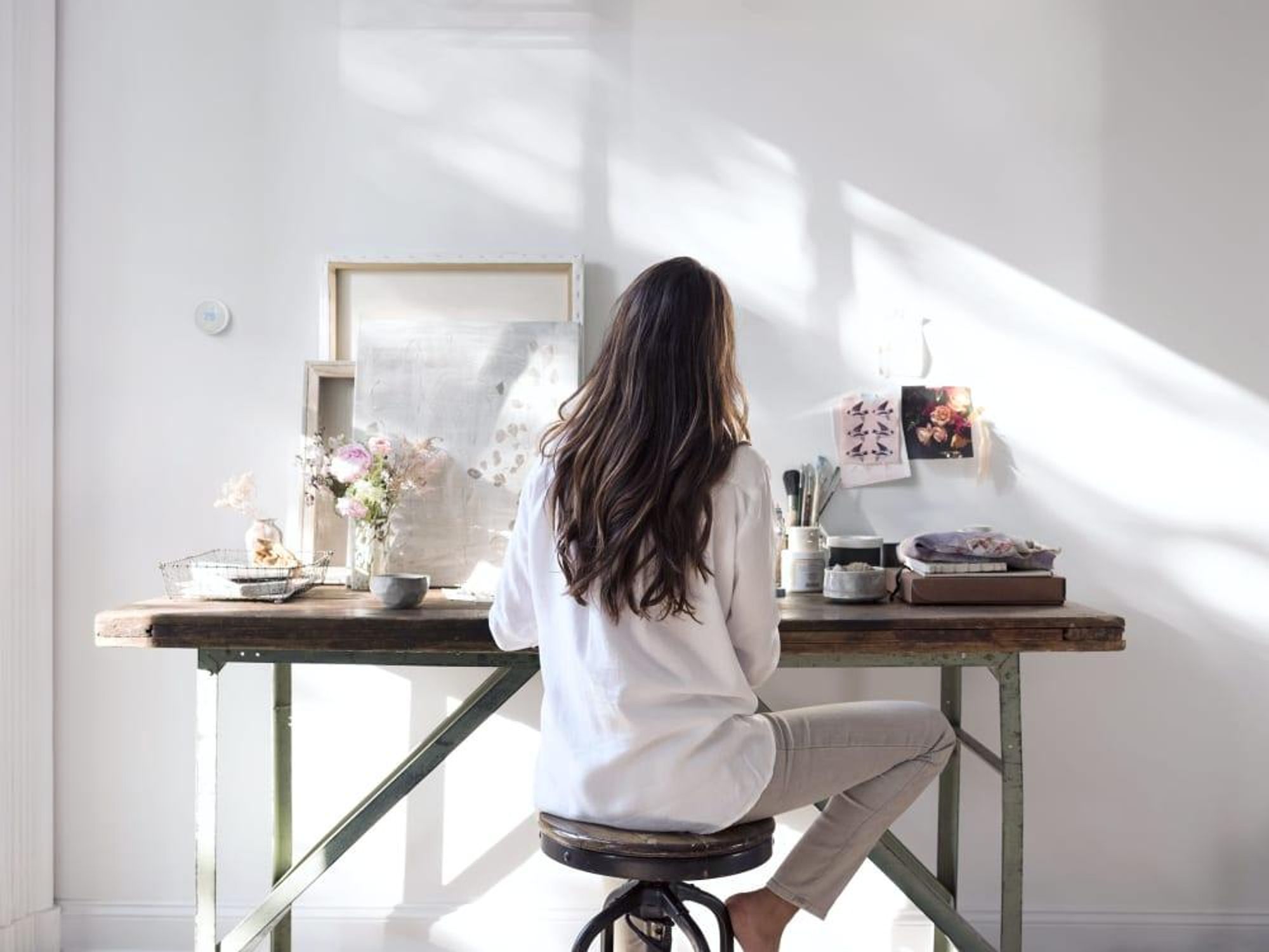 Woman working at a computer with a Nest E Thermostat