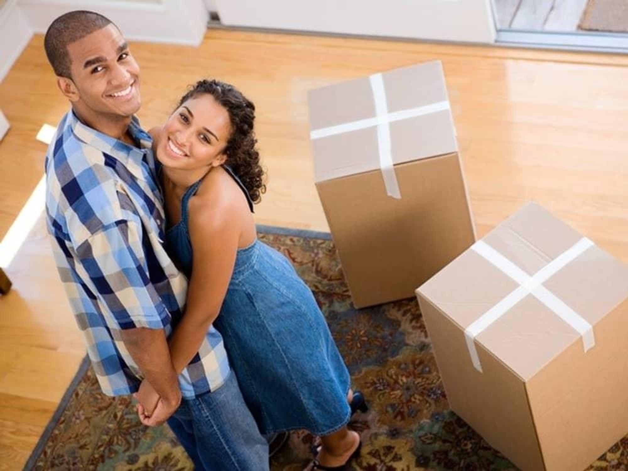 young couple with boxes moving into new house